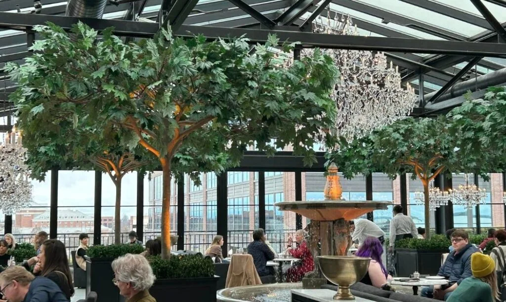 The interior of RH Rooftop in Columbus with a Chandelier and trees.