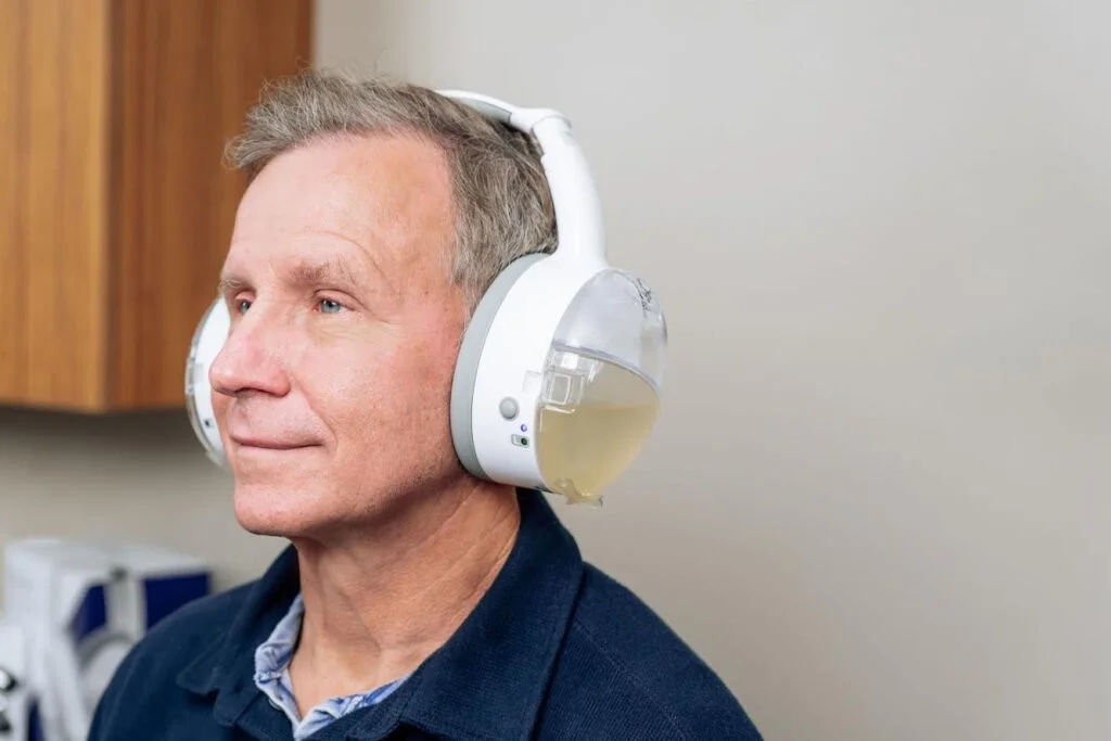OtoSet ear cleaning device in the process of massaging, washing, and vacuuming out a patient's ear.