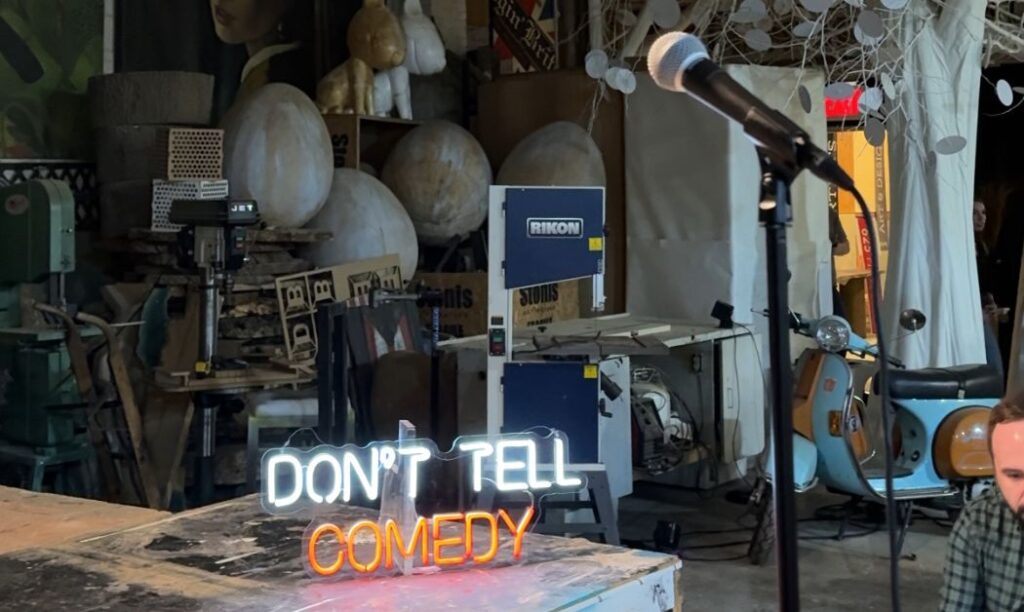 Don't Tell Neon lights on the stage and art pieces in the design studio