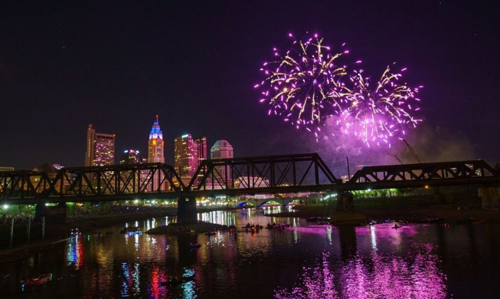 Fireworks in Columbus, Ohio with the Scioto River and a bridge in the foreground
