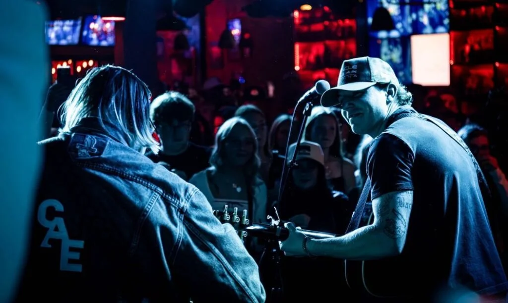 Country artists performing at Bristol Republic with spectators looking on.