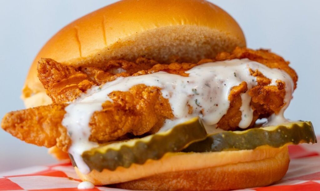 A chicken sandwich with pickles and dripping homemade ranch