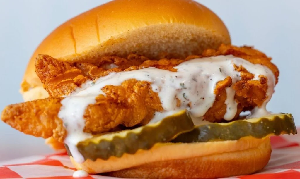 A chicken sandwich with pickles and dripping homemade ranch