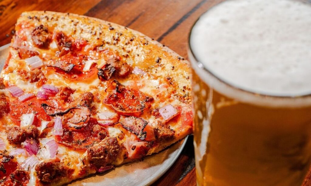 A beer and a slice of Mikey's Late Night Slice.