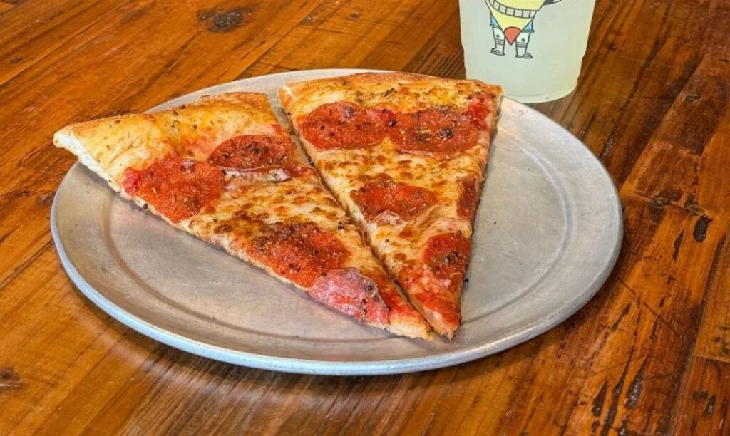 A slice of Mikey's Late Night Slice Pizza cut in half as part of their "Kids Eat Free in September" Promo.